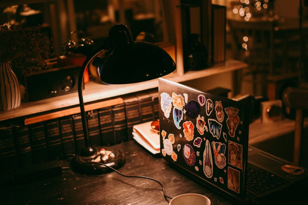 The Entrepreneur’s Guide to Turning Ideas Into Profitable Warm lighting illuminates a workspace with a laptop, lamp, and books.